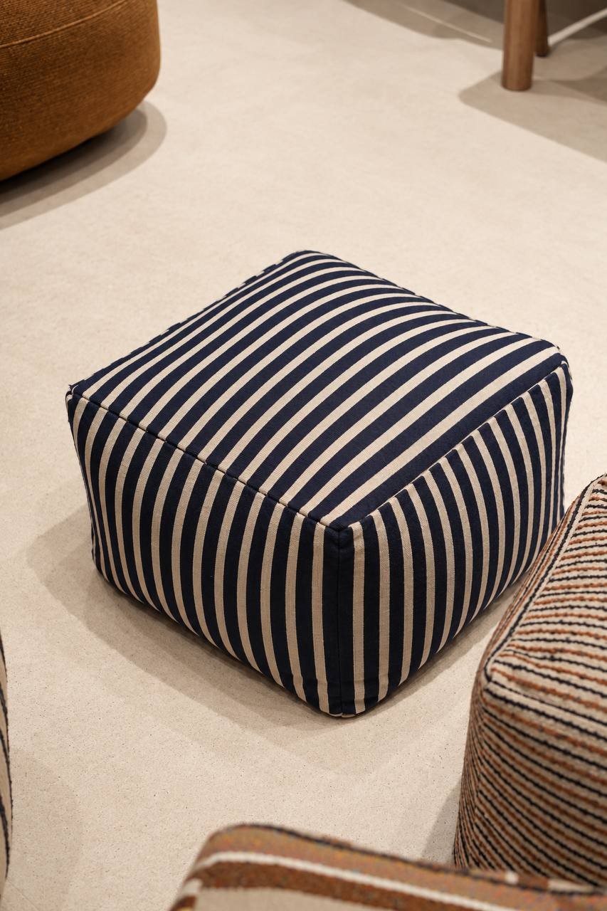 Navy blue and cream striped upholstered pouf by NicChris, featuring a soft square design with rounded corners, ideal as a modern living room accent stool or footrest